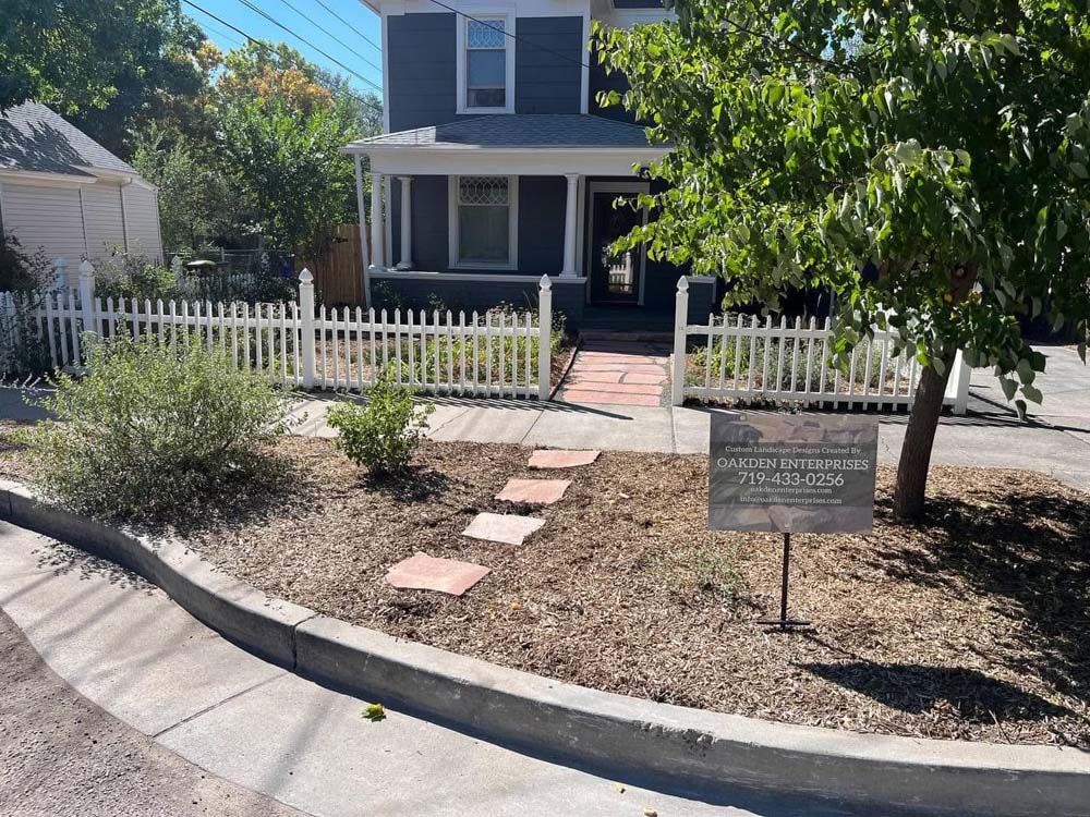 Blue house with white picket fence and a sign.