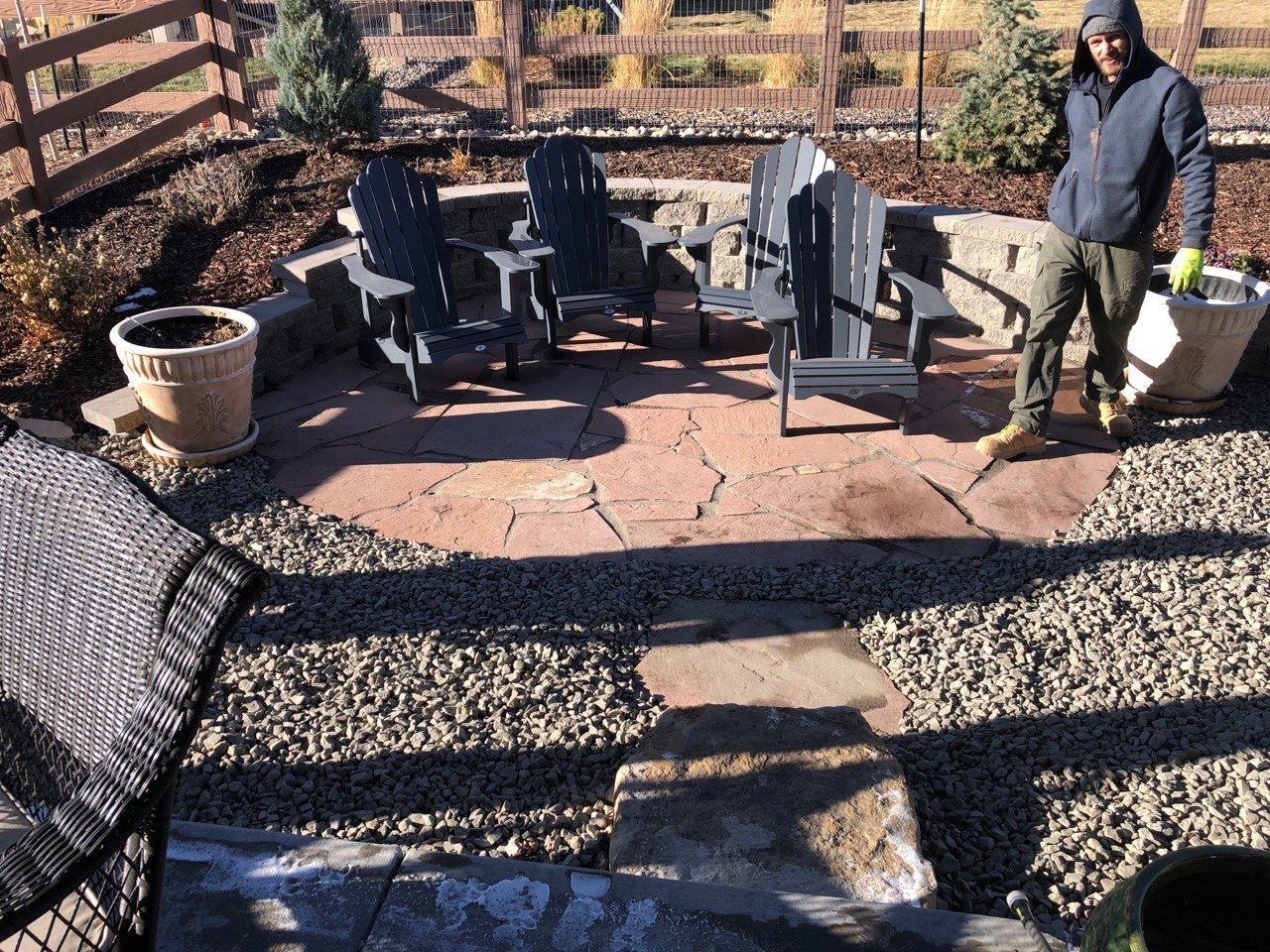 A man standing in front of a patio with chairs