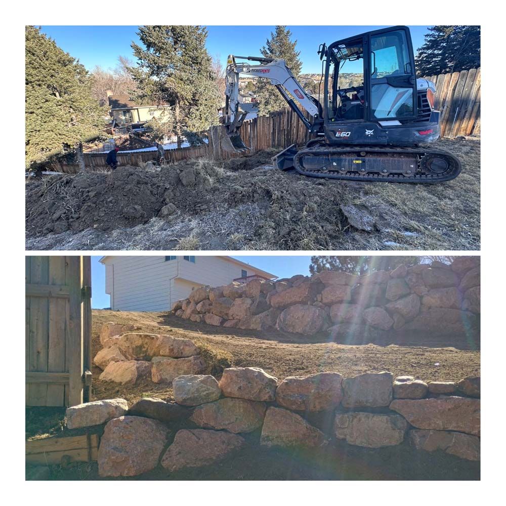 Construction of a retaining wall. An excavator digs earth in a backyard. A completed wall is built with large, reddish-brown rocks.