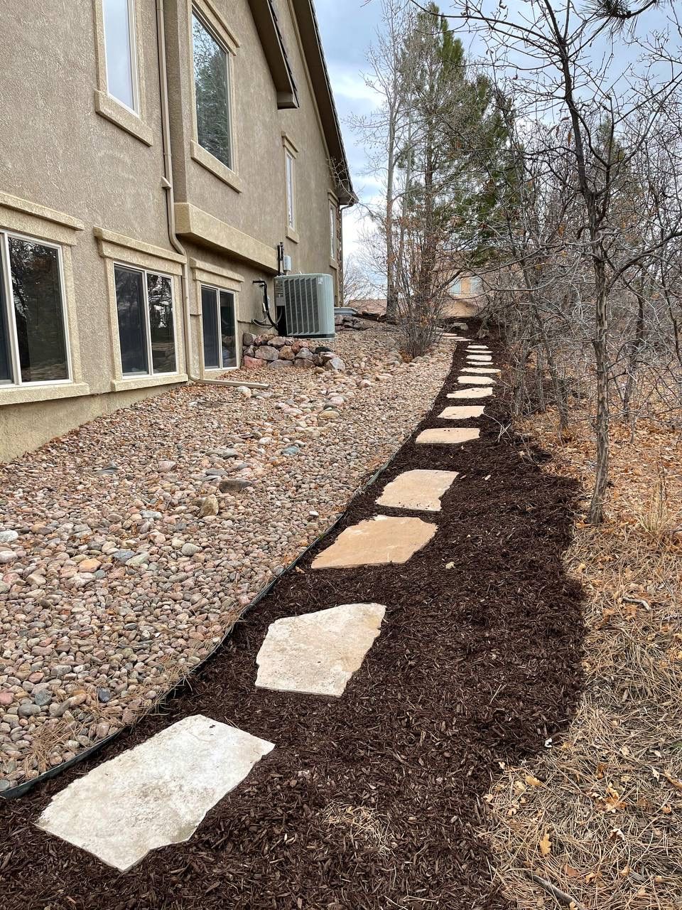 A walkway with stepping stones leading to a house.