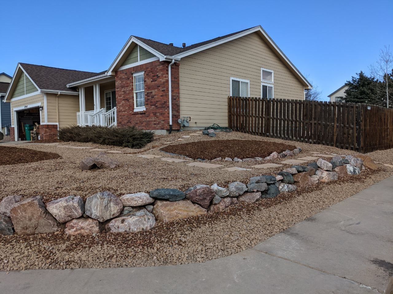 A house with a stone wall in front of it