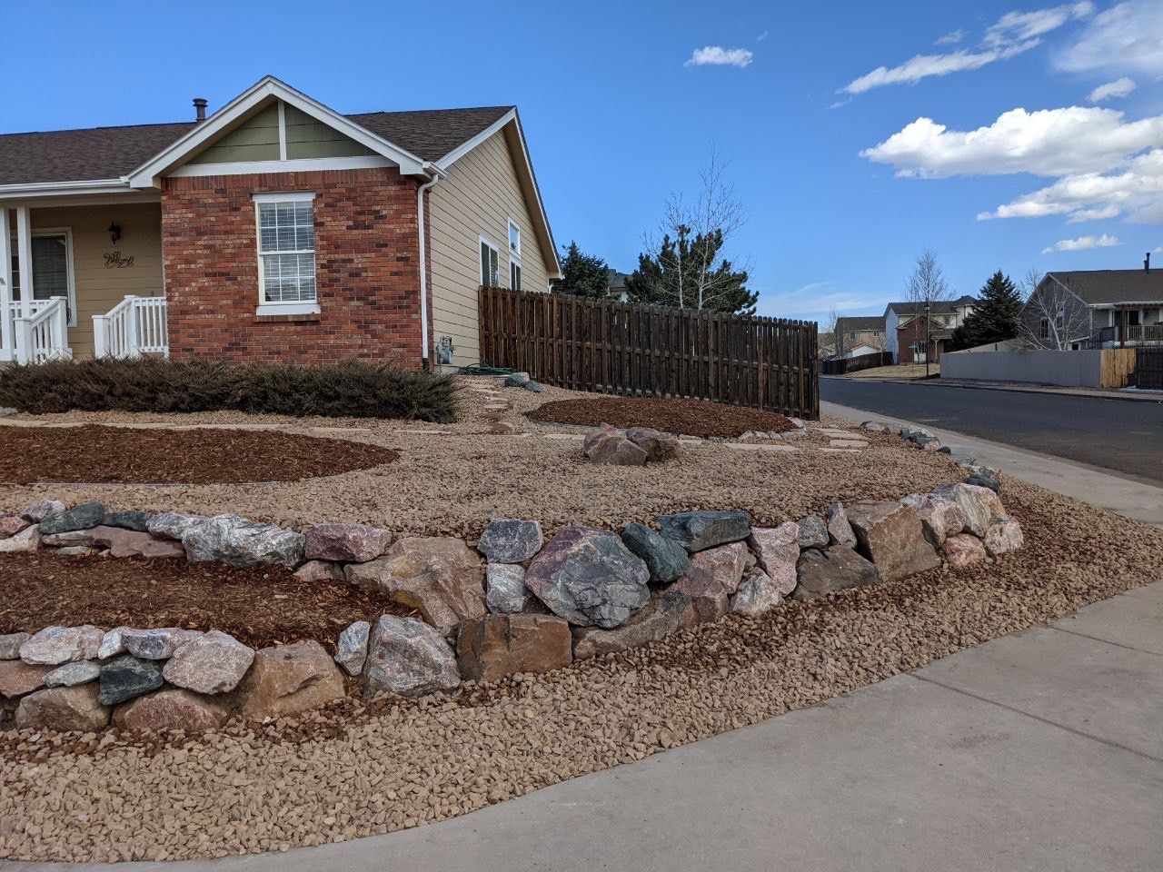 A brick house with a stone wall in front of it