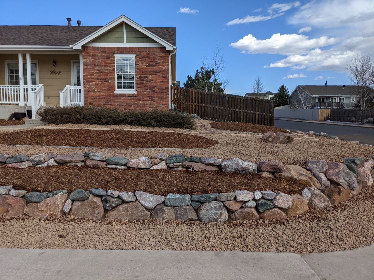 A brick house with a stone wall in front of it