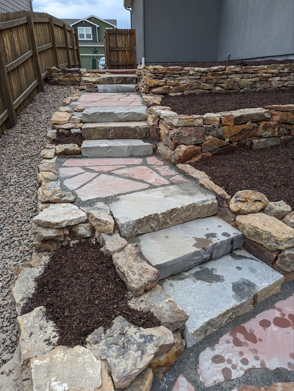 A stone walkway with stairs leading up to a house