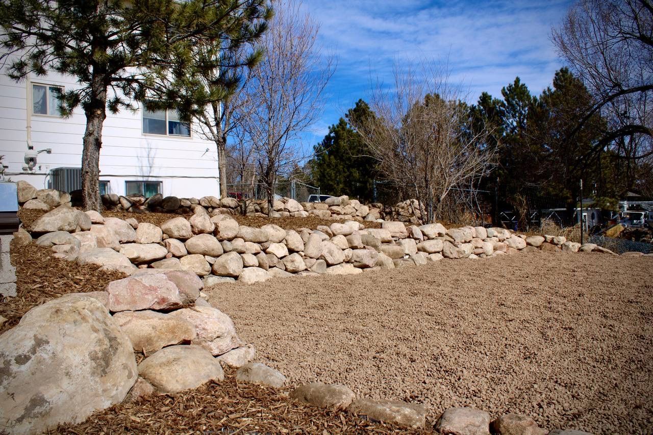 A large pile of rocks in front of a house