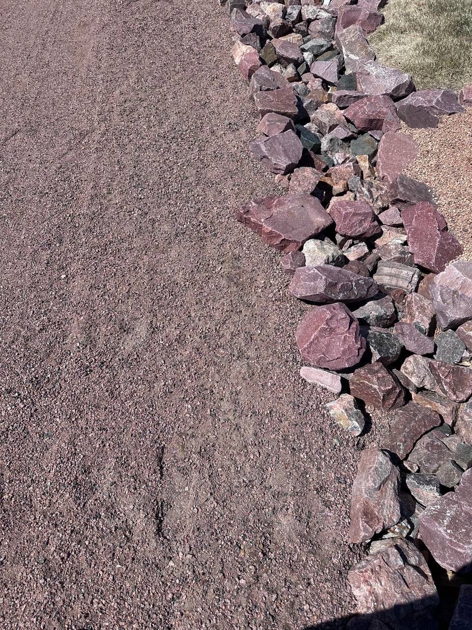 A row of rocks sitting on top of a gravel road.