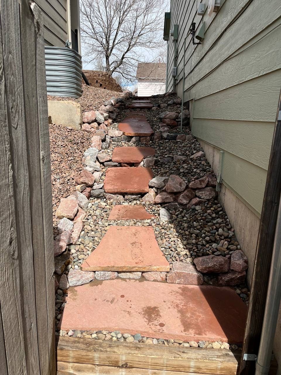 A stone walkway leading to the side of a house