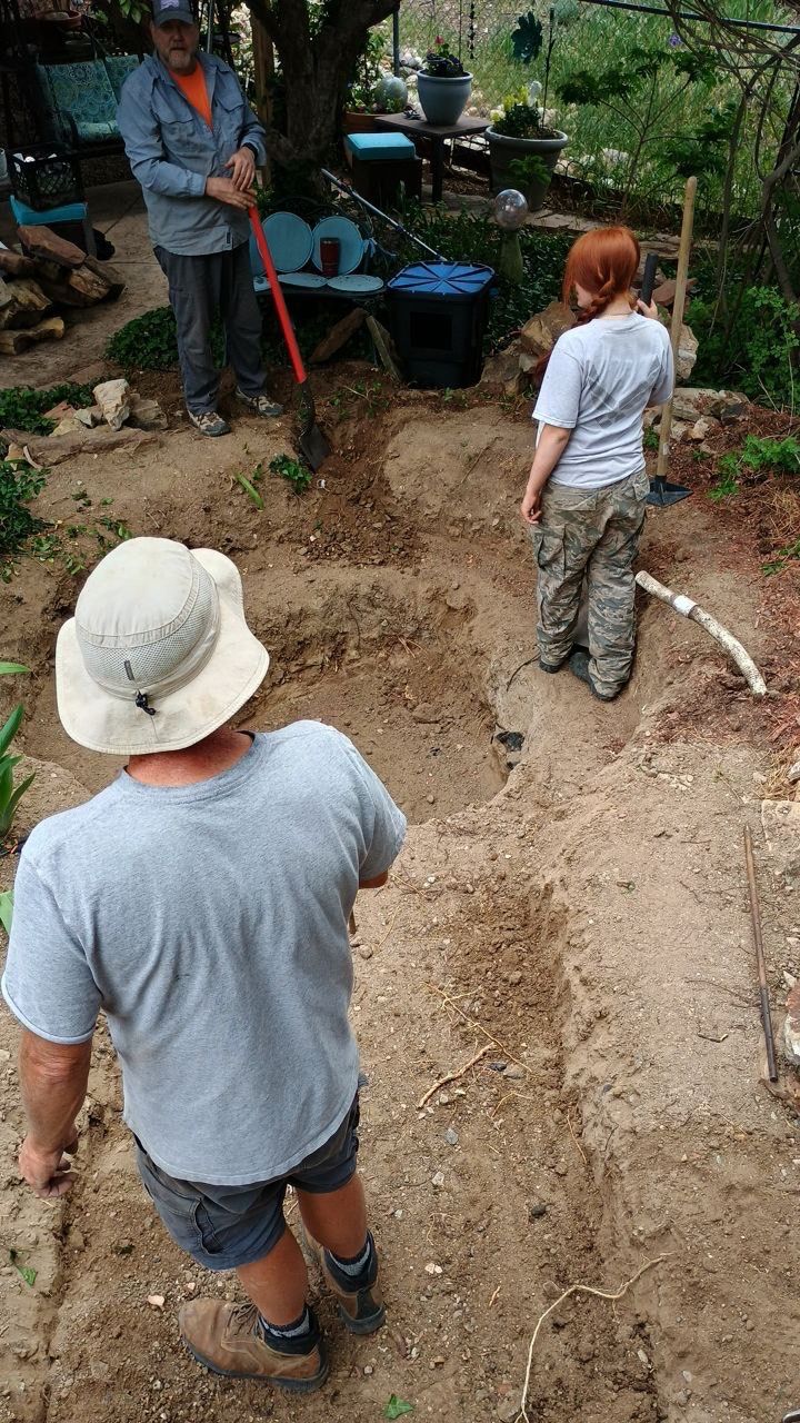 A man wearing a hat is standing in the dirt