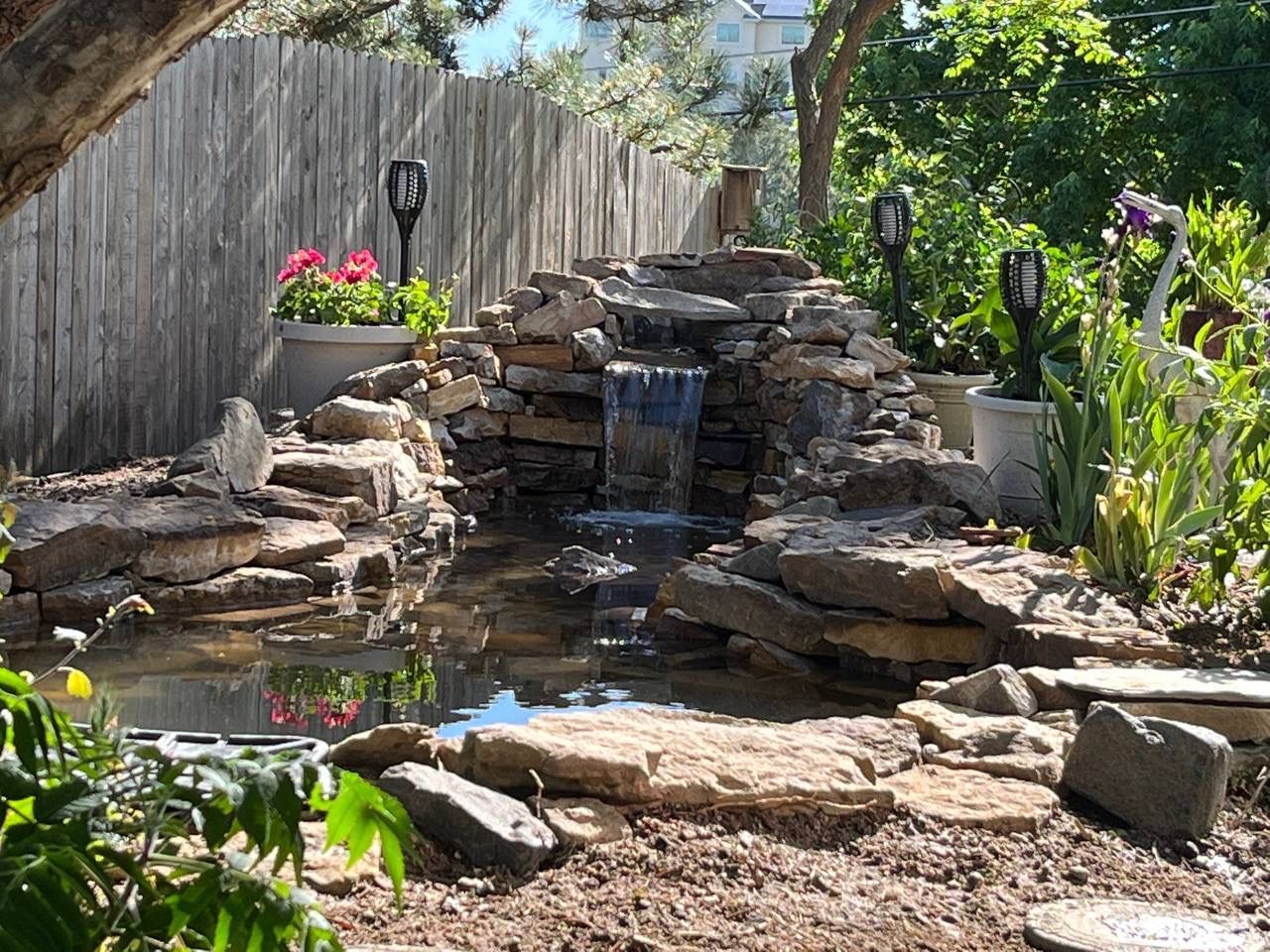 A small pond with a waterfall in the backyard