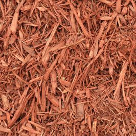 A pile of red mulch is sitting on the ground.