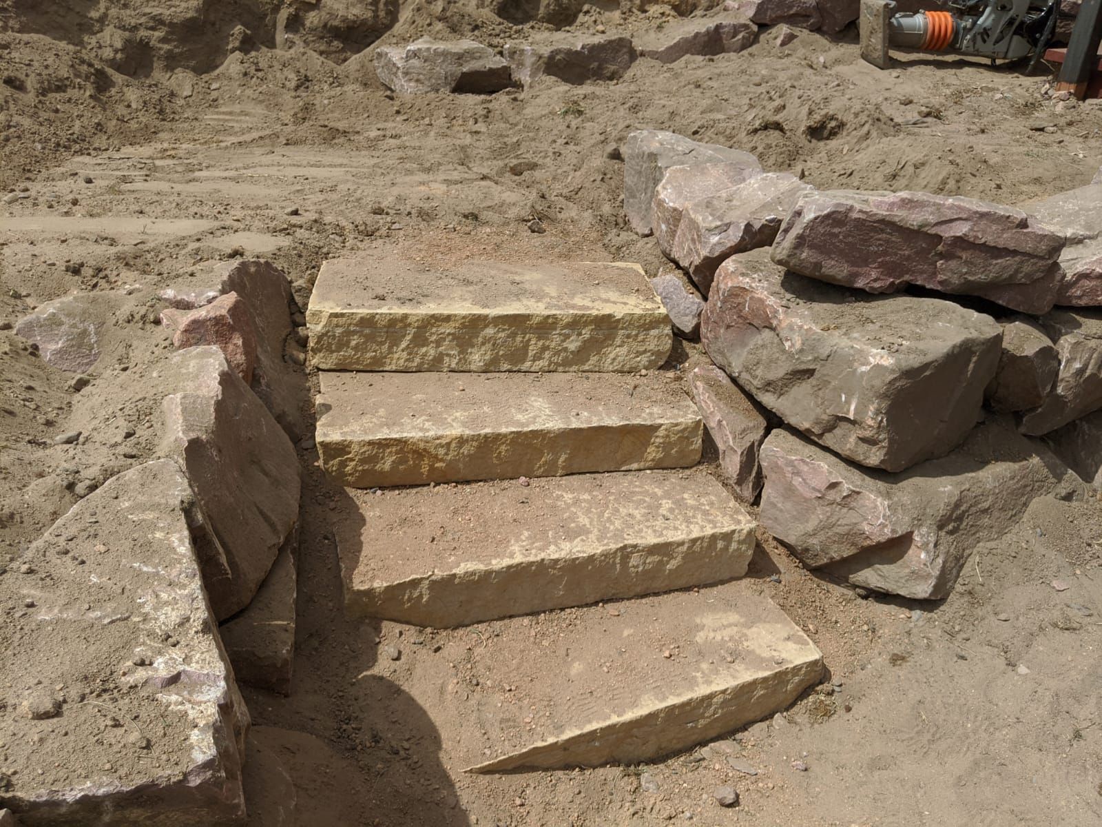 A set of stairs made of rocks in the dirt