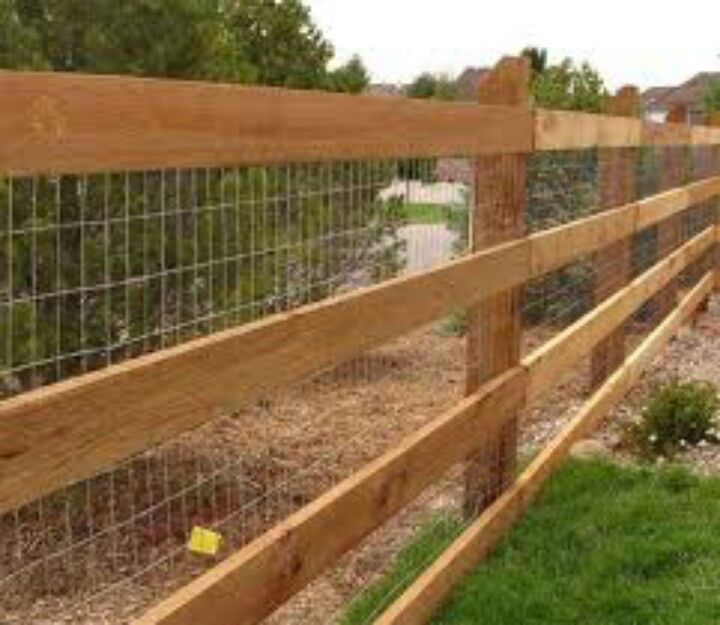A wooden fence with a wire fence attached to it.