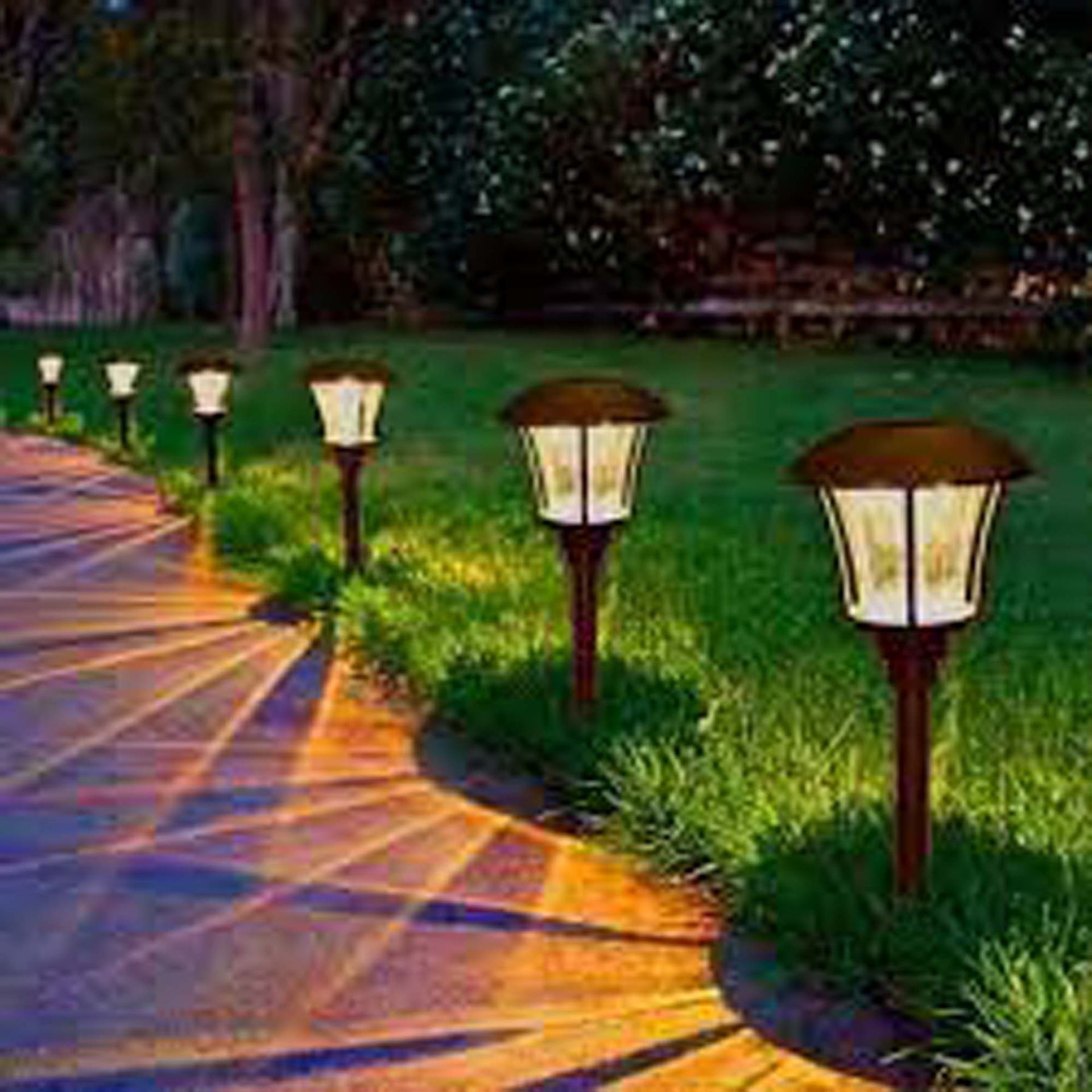 A row of solar powered lanterns along a path in a park.