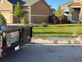 A dumpster is parked in front of a house.