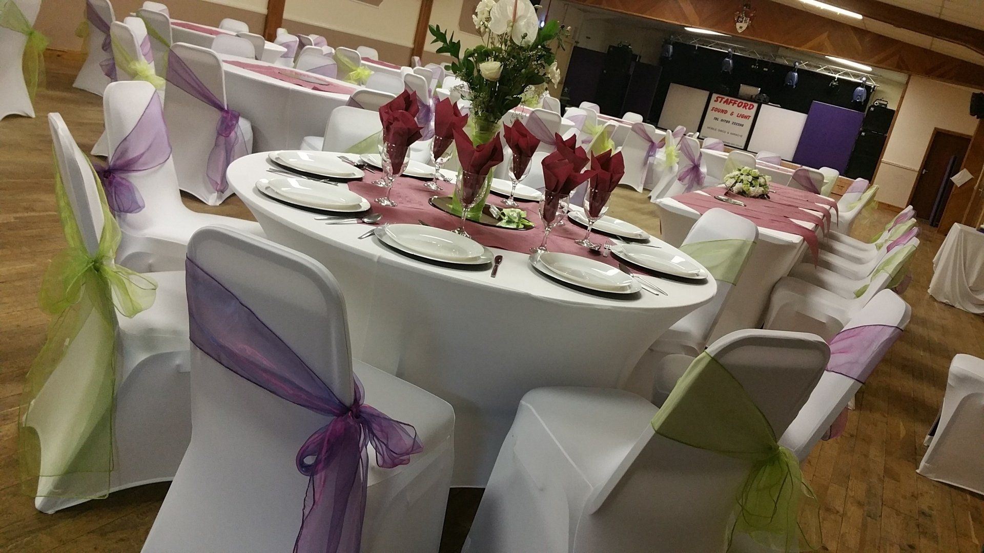 A room with tables and chairs set up for a wedding reception.