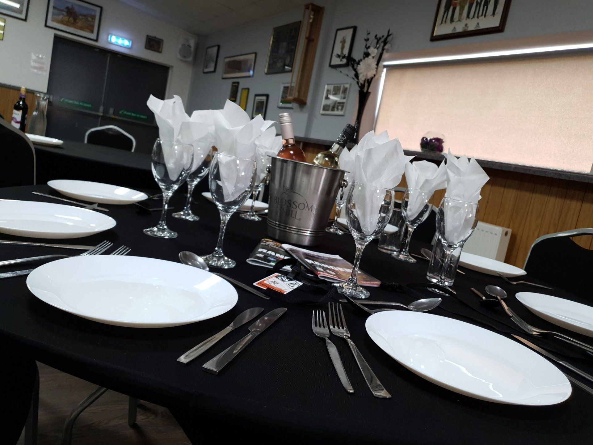 A table is set with plates , glasses , silverware and napkins.