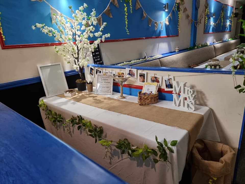 A table with a white table cloth and a sign that says mr. and mrs.
