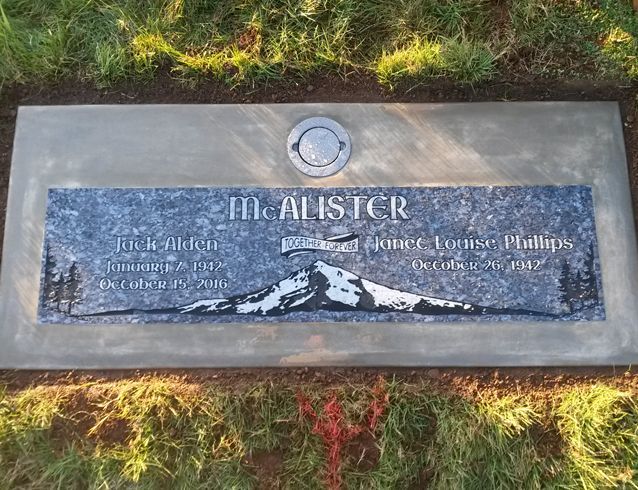 A gravestone with a picture of a mountain on it.