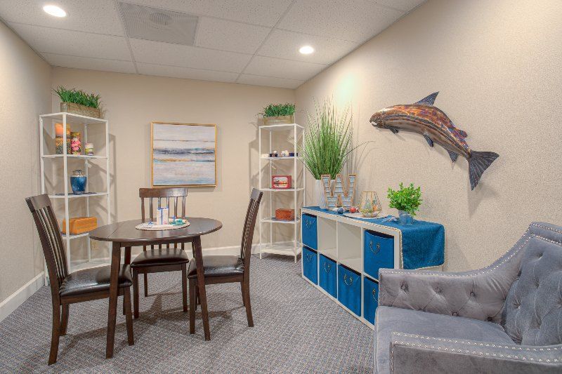A living room with a table and chairs and a fish on the wall.