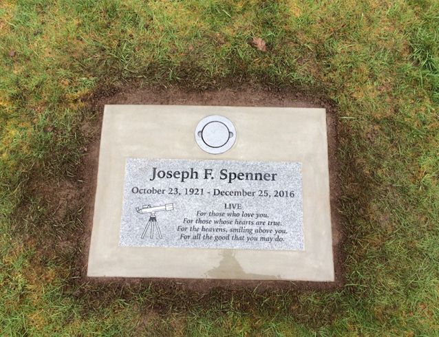A gravestone for joseph f. spinner is in the grass.