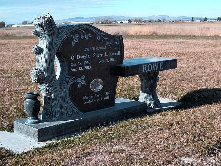 A gravestone with a bench in front of it that says rowe