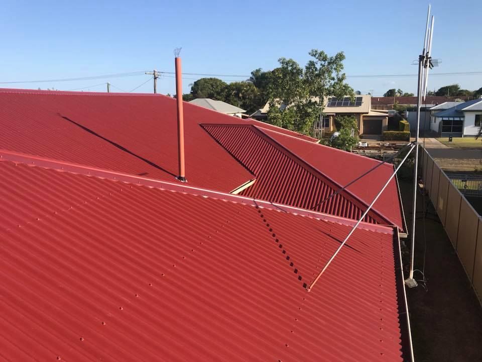 A Corrugated Metal Roof of A House with Antennas — Kaplan Roofing in Walkervale, QLD