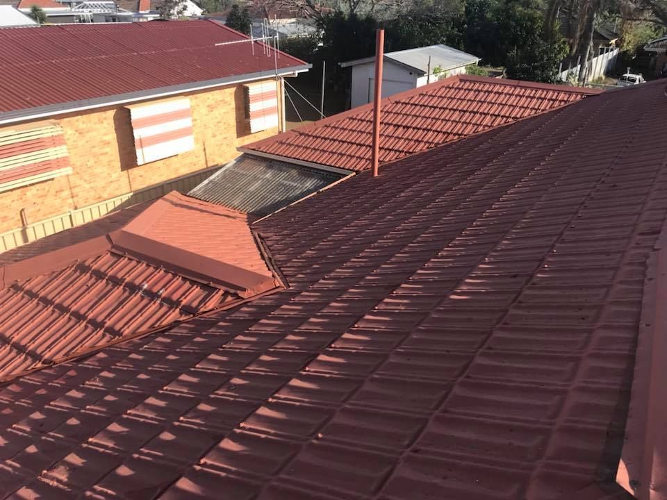A Tiled Roof with A Skylight and Chimney — Kaplan Roofing in Walkervale, QLD