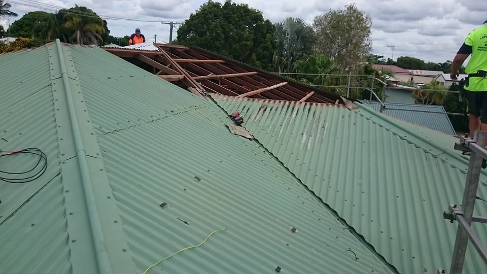 A Corrugated Roof Partially Dismantled with Construction Workers — Kaplan Roofing in Walkervale, QLD