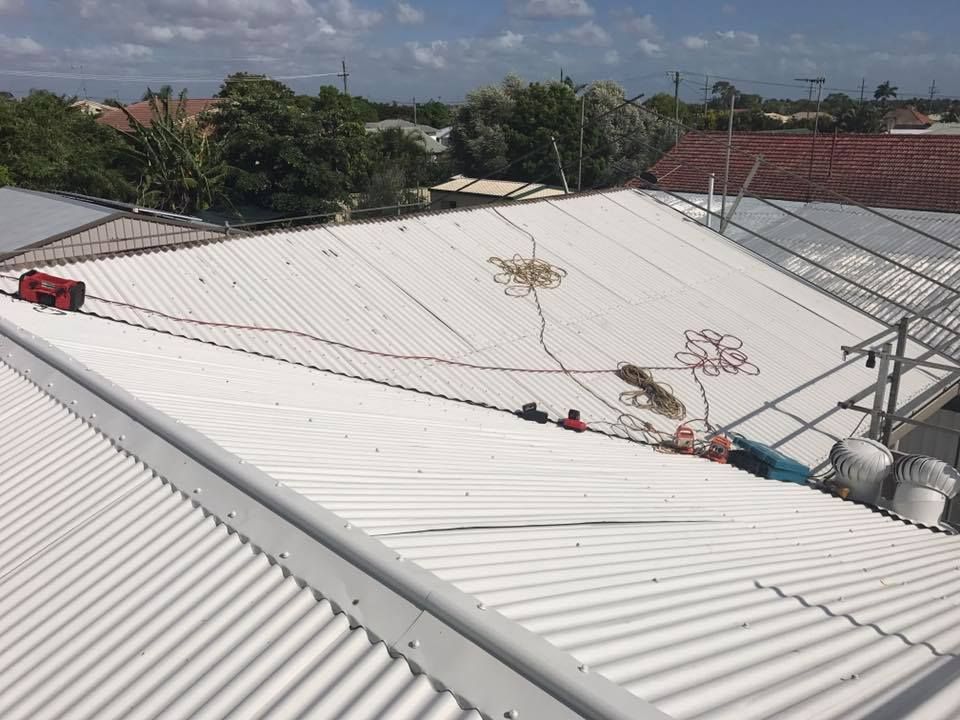 A Corrugated Metal Roof with Tools and Wires — Kaplan Roofing in Walkervale, QLD