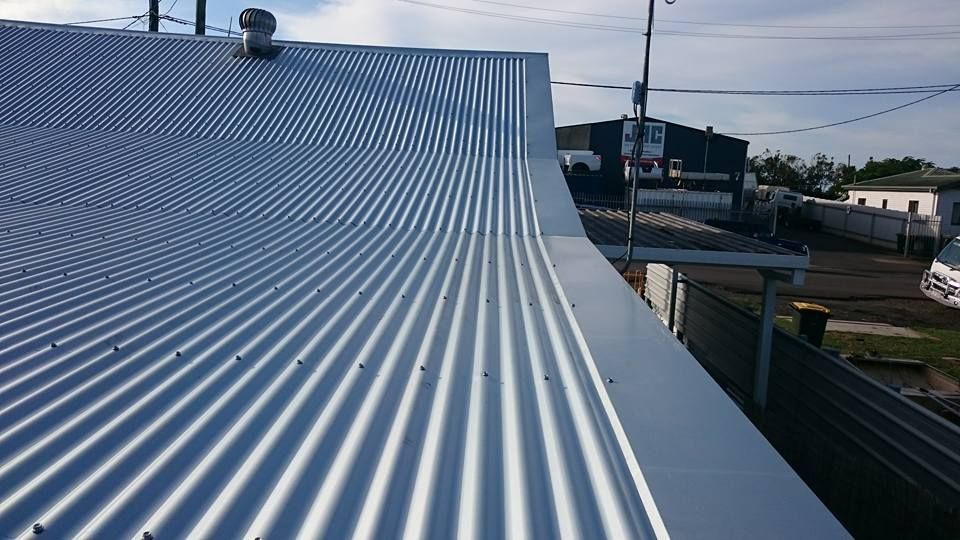 A Corrugated Metal Roof, Bright Silver, with Curved Edge — Kaplan Roofing in Walkervale, QLD