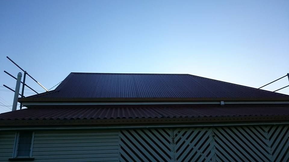 A Corrugated Metal Roof on A Building with Safety Rails — Kaplan Roofing in Walkervale, QLD