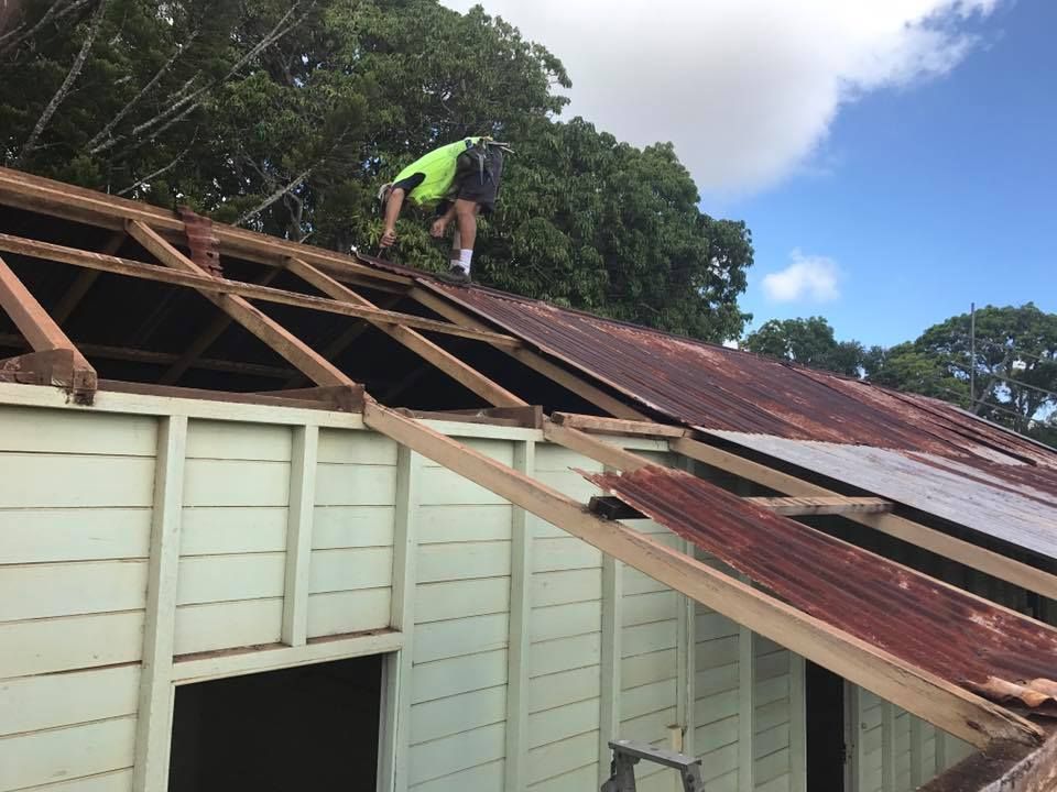 A Person Removing Old Corrugated Iron Sheets — Kaplan Roofing in Walkervale, QLD