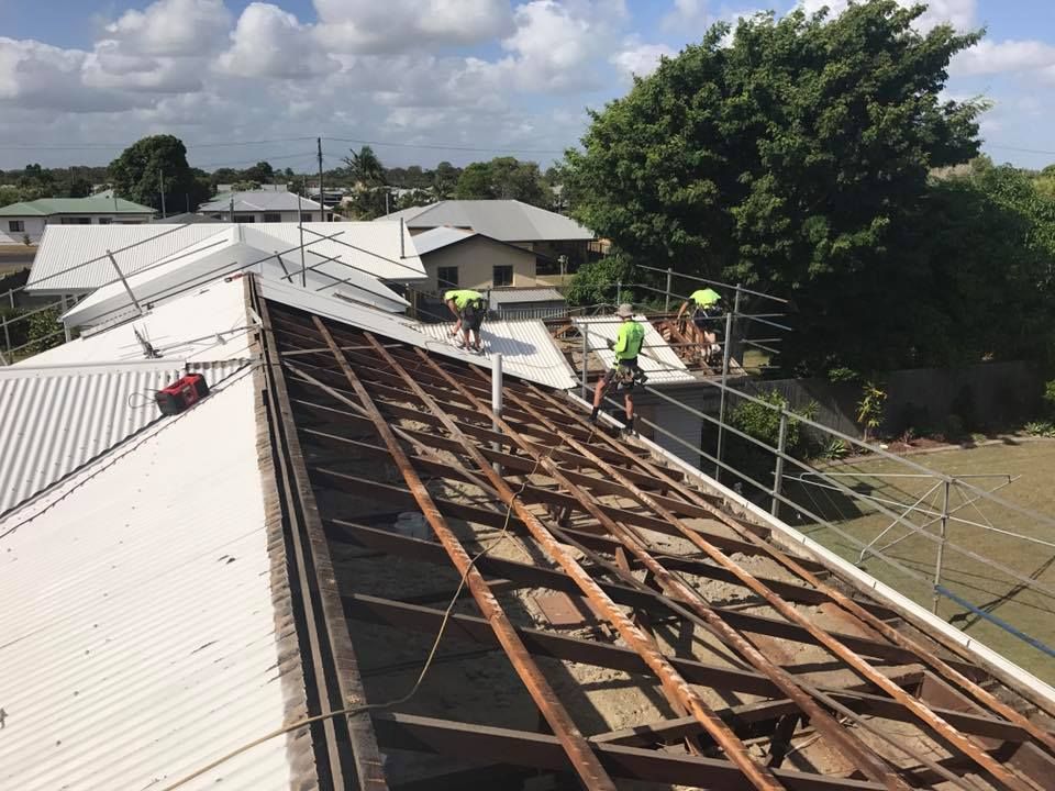 A Worker on A Roof Removing and Replacing Old Boards — Kaplan Roofing in Walkervale, QLD
