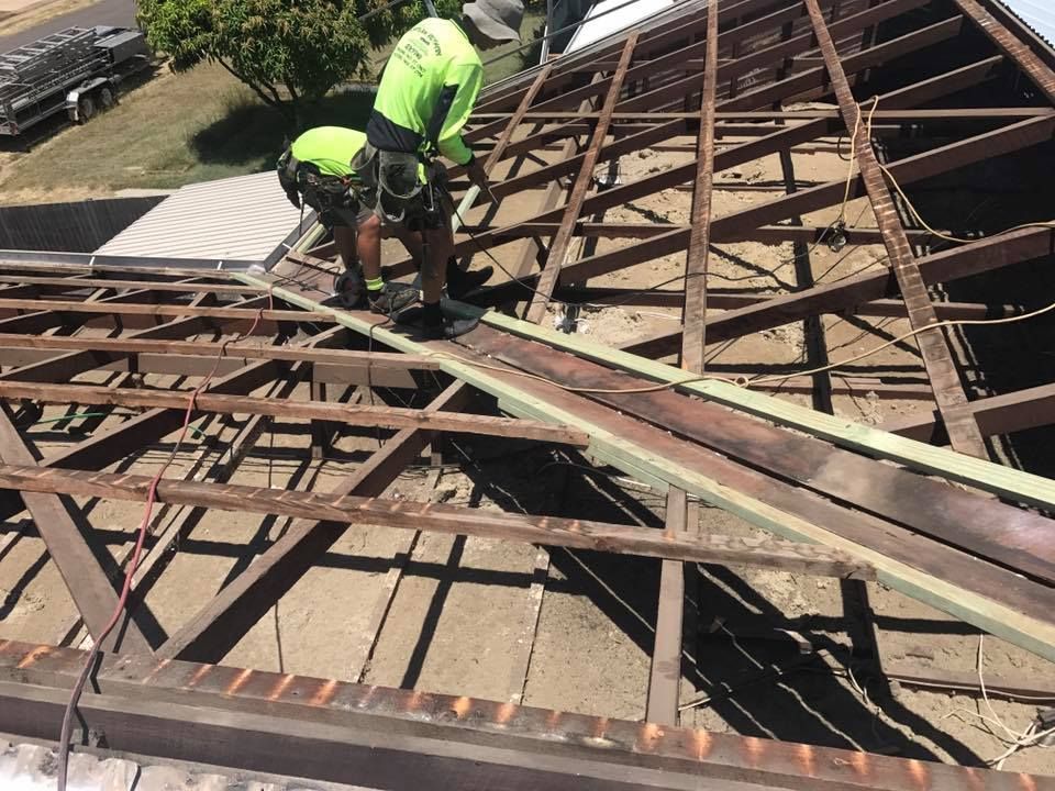Two Construction Workers on A Rooftop Framework — Kaplan Roofing in Walkervale, QLD