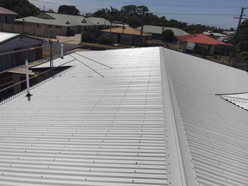 A Corrugated Metal Roof on A House in A Residential Area — Kaplan Roofing in Walkervale, QLD