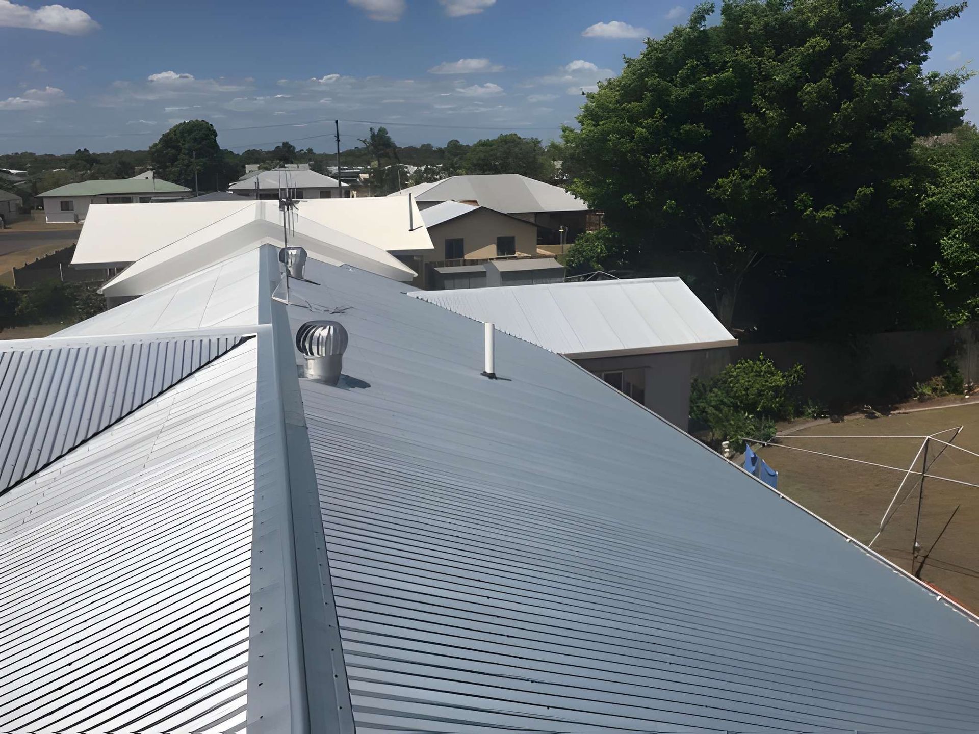 A Corrugated Metal Roof of A Building with Multiple Vents — Kaplan Roofing in Walkervale, QLD