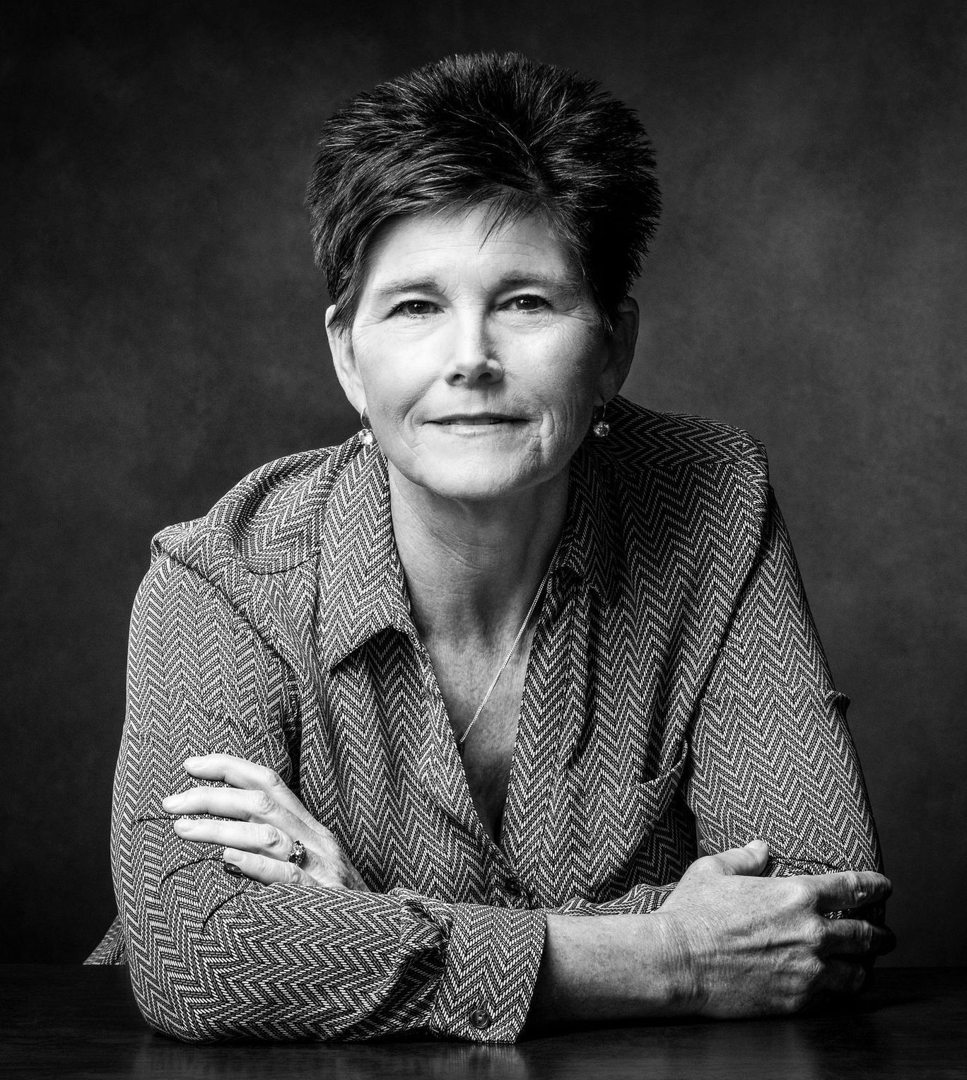 Kathy Taylor
 in a blue shirt is standing next to a white horse.