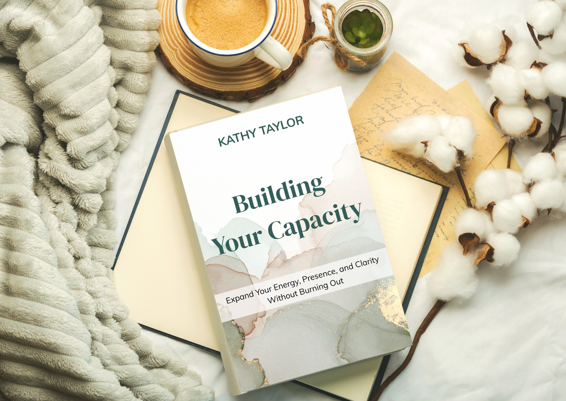 Book, cup of coffee, and lavender sprig on a brown surface. The book's title is