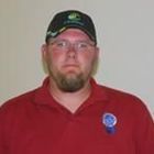 Man wearing a black cap and red polo shirt against a plain background
