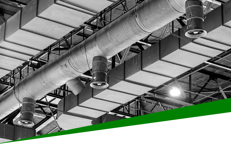 Industrial ceiling with large ventilation ducts and skylights in black and white, accented by a green diagonal bar