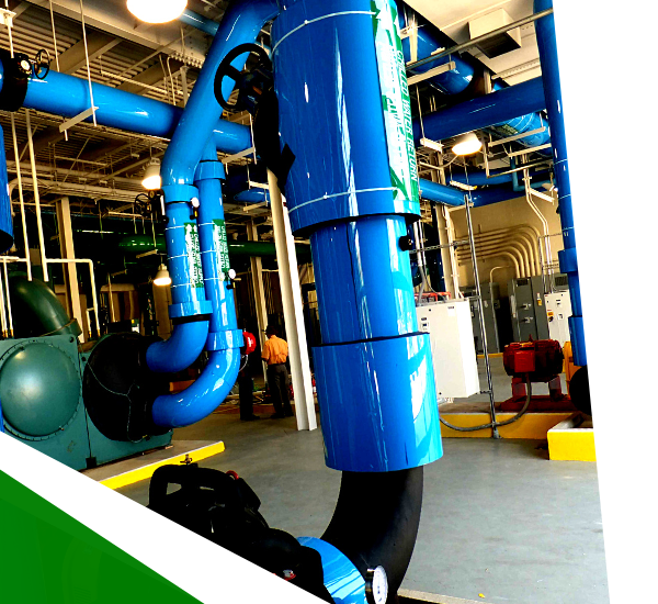 Blue industrial pipes and machinery inside a factory or utility plant.