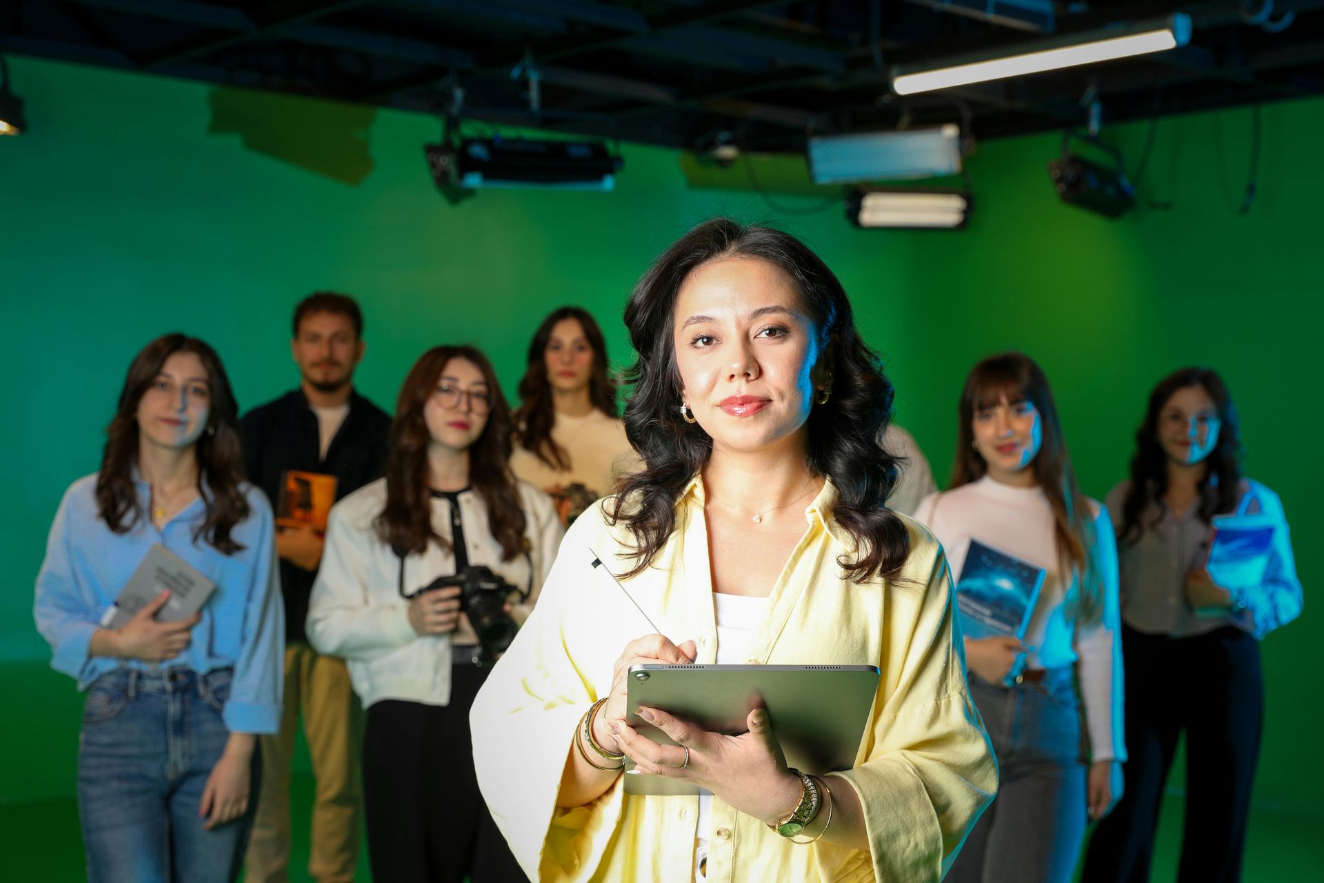 Un groupe de personnes se tient devant un écran vert.