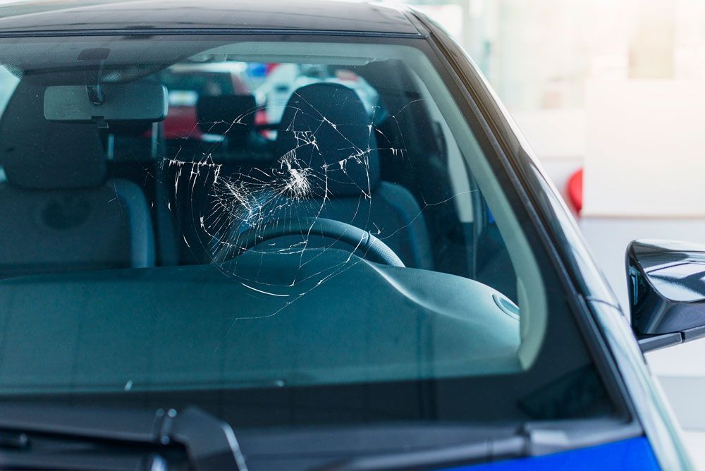 a car with a broken windshield is parked in a parking lot