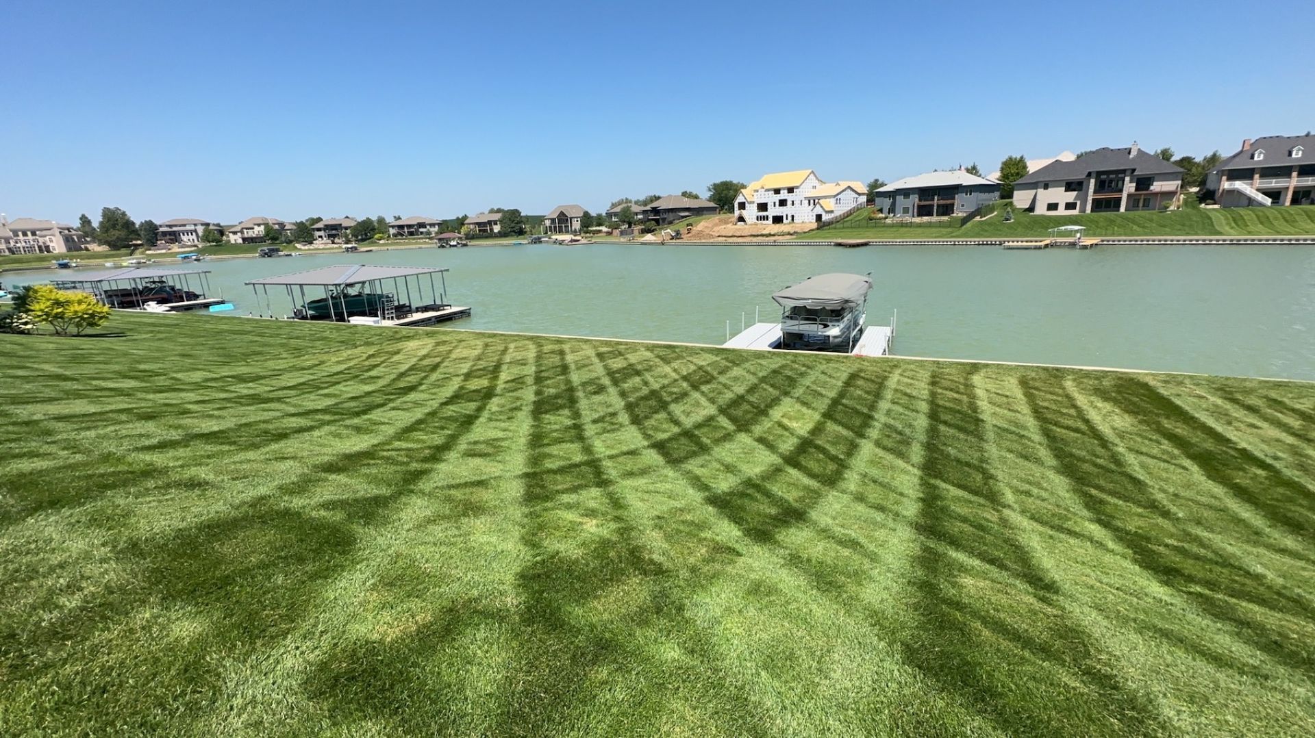 A boat is parked on a dock next to a lake.