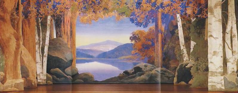 A stage with a painting of trees and a lake in the background