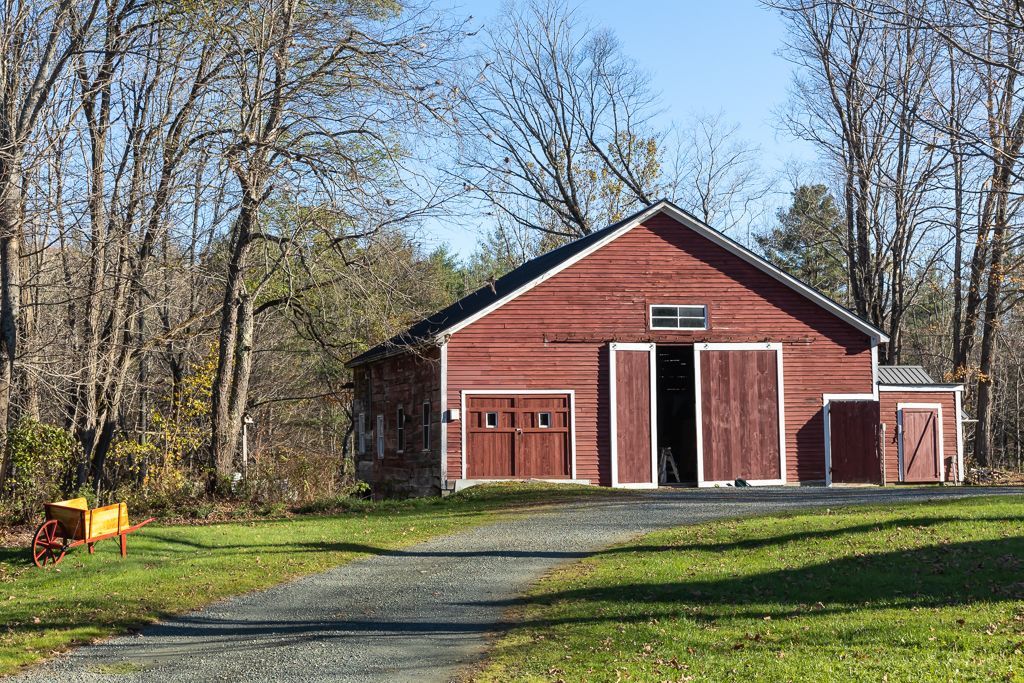 A red barn sits in the middle of a grassy field