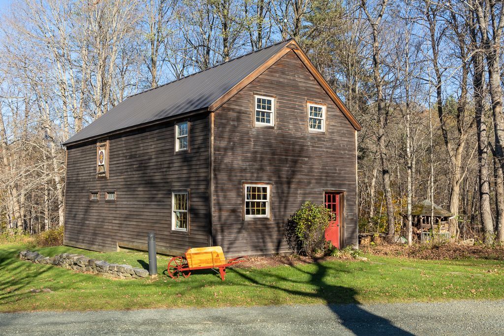 A house with a red door and a yellow wheelbarrow in front of it