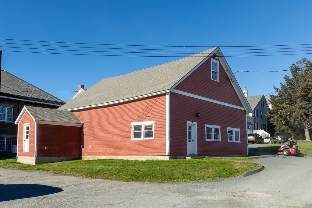 A red barn with a gray roof and white trim