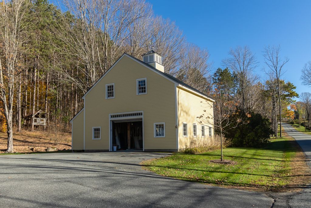 A large yellow building with a garage and a chimney