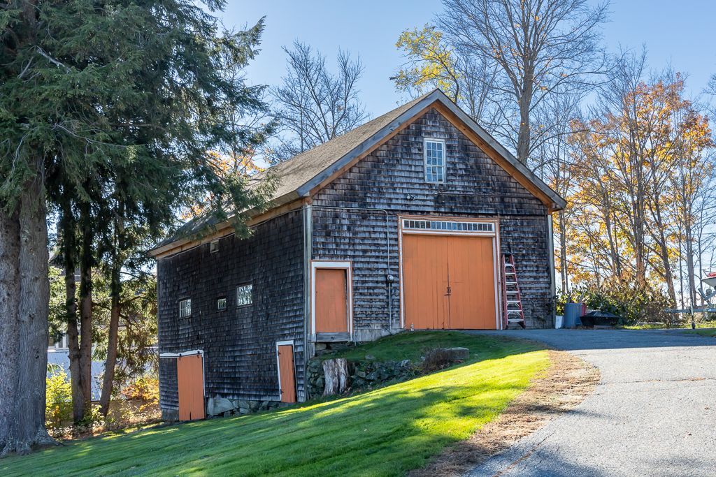 A very old barn with a large orange door